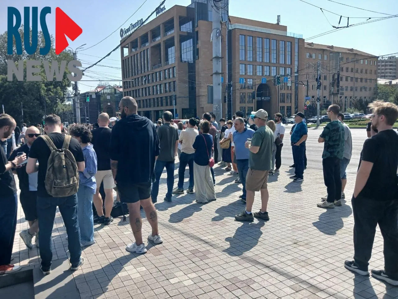 Перед посольством России в Ереване к полудню образовалась длинная очередь желающих проголосовать. Рядом проходит митинг, участники которого держат плакаты.